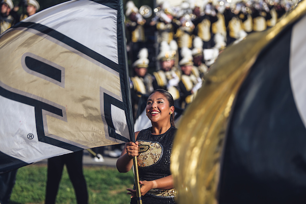 photo of purdue all-american twirling team member smiling with a purdue p logo flag