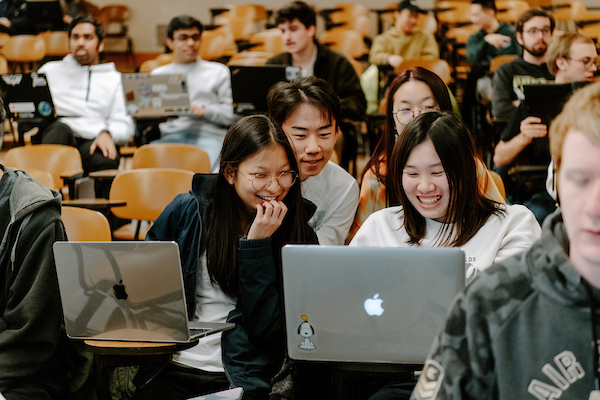 photo of students sitting in a lecture hall on their computers