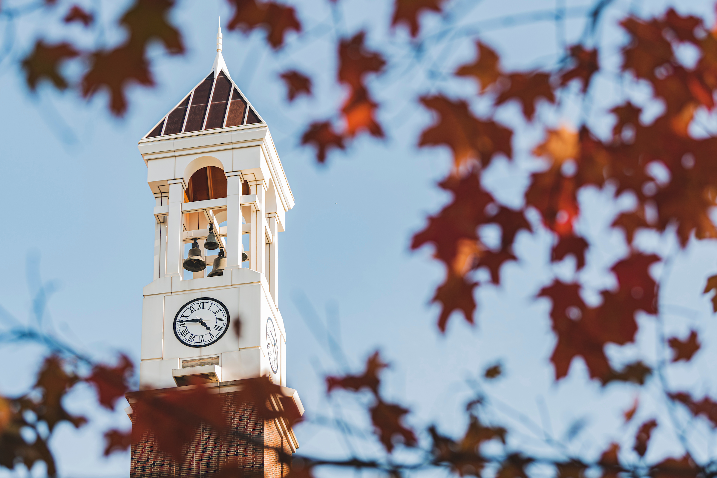 Purdue's Bell Tower is framed by red fall leaves
